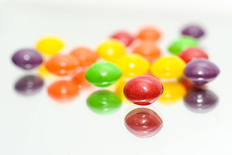 Colorful jelly beans on white reflective surface