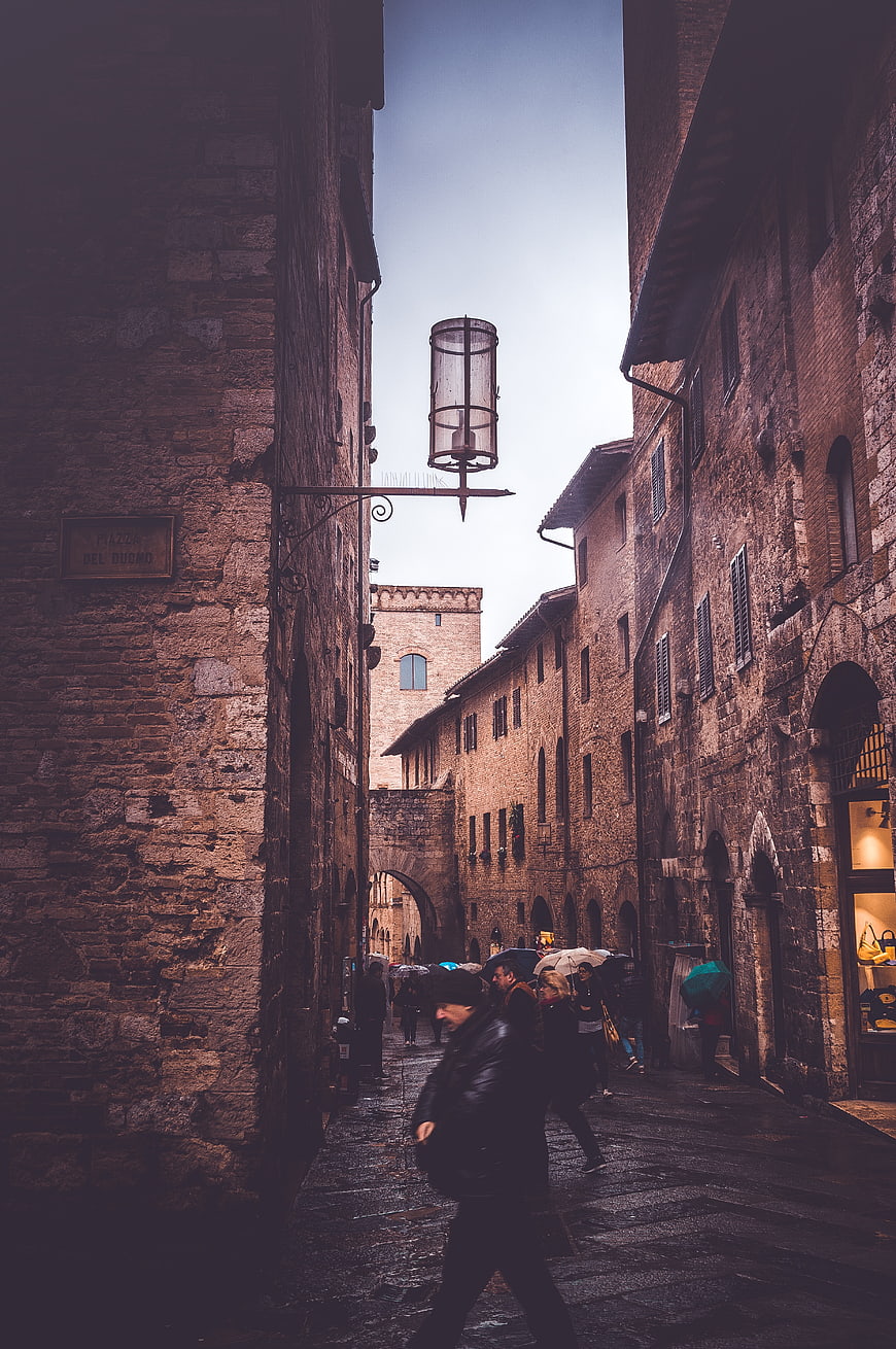 Rainy Medieval Street in San Gimignano with Pedestrians