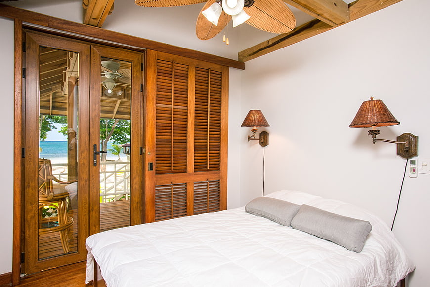 Tropical Bedroom Interior with Ocean View and Wooden Shutters