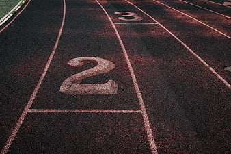 Close-up of running track lanes with number two painted on surface