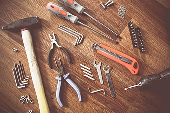 Assorted Hand Tools and Hardware on Wooden Surface