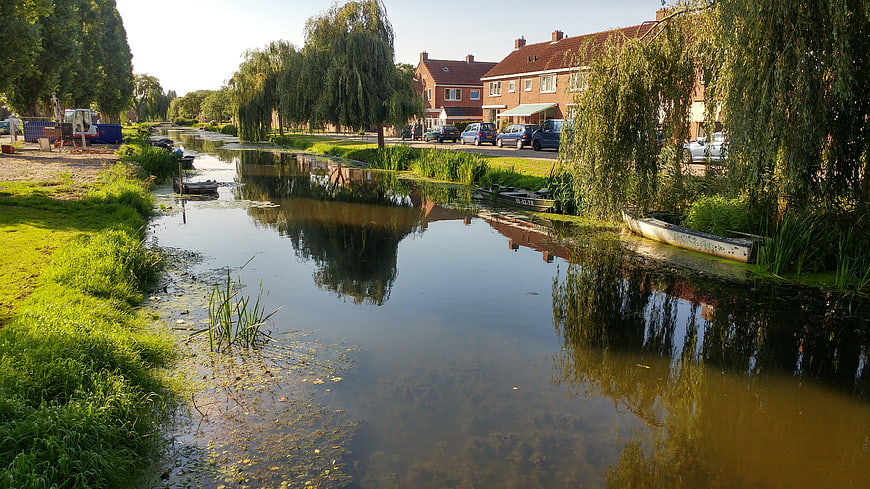 Serene Canal Scene with Brick Houses and Weeping Willows