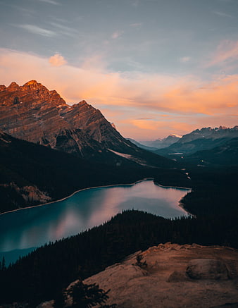 Sunset over turquoise mountain lake with alpine peaks
