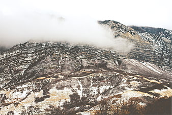 Snowy mountain landscape with fog and rolling hills