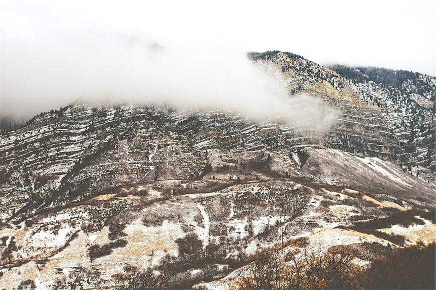 Snowy mountain landscape with fog and rolling hills
