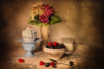 Vintage still life with cupcake, berries, and flowers