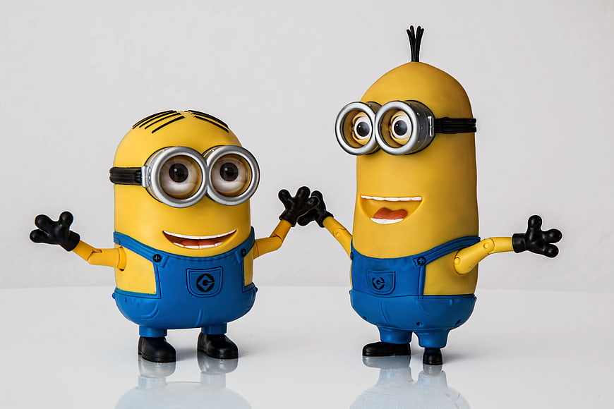Two Minion Action Figures Standing on White Background