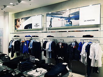 Modern menswear retail store interior with clothing racks and branding
