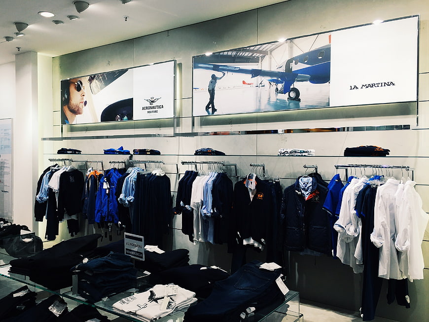 Modern menswear retail store interior with clothing racks and branding