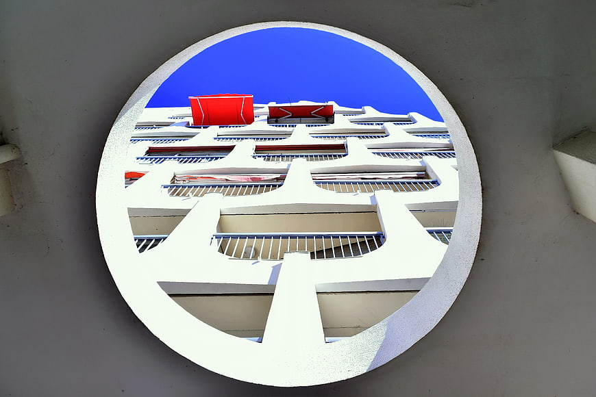 Modern white apartment building viewed through circular window frame