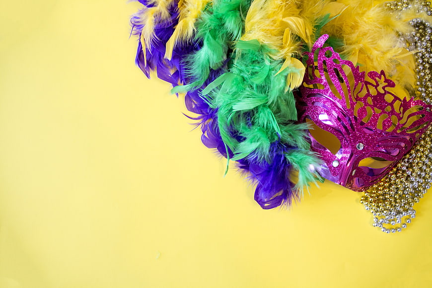 Mardi Gras Mask and Feathers on Yellow Background