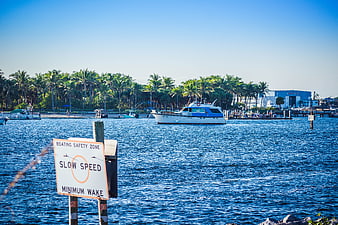 Boating Safety Zone Sign in Tropical Harbor with Boat