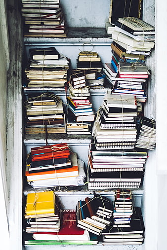 Stacks of old books tied with twine on shelves