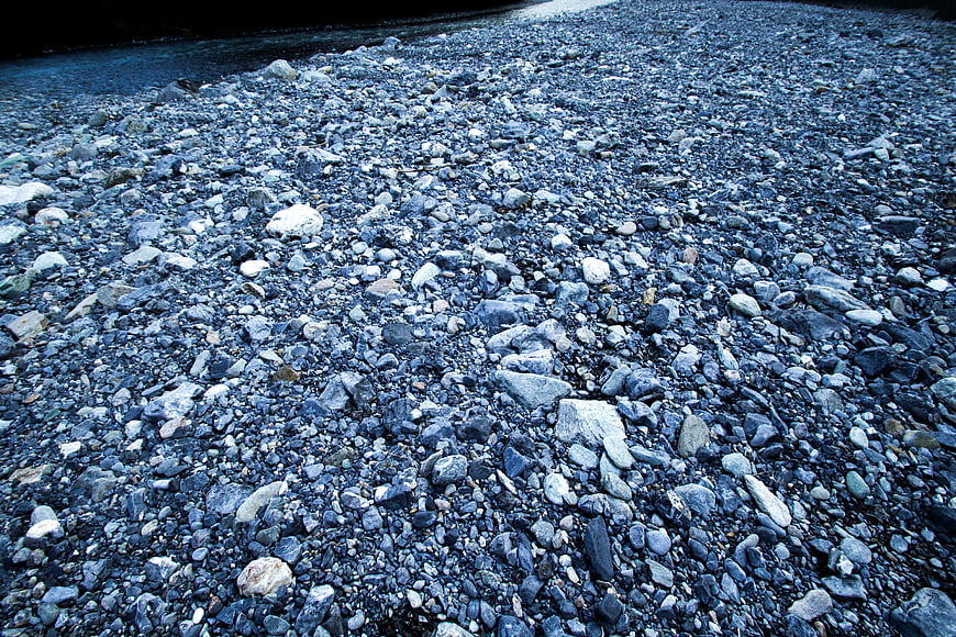 Close-up of gray and white stone fragments on a rocky riverbank