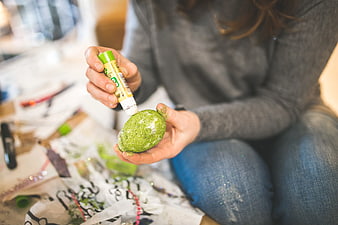 Woman Gluing Green Glitter to Easter Egg
