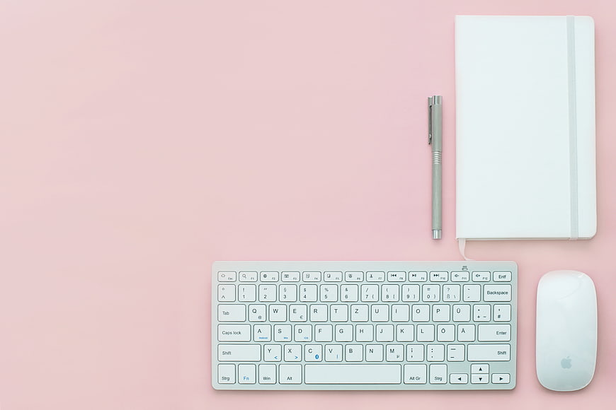 Minimalist Pink Workspace Flat Lay with Keyboard and Notebook