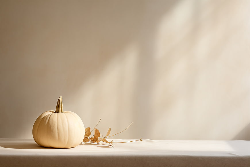 Minimalist White Pumpkin with Dried Leaves on Beige Background