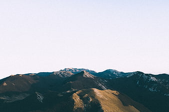 Serene Mountain Landscape with Snow-Capped Peaks and Clear Sky