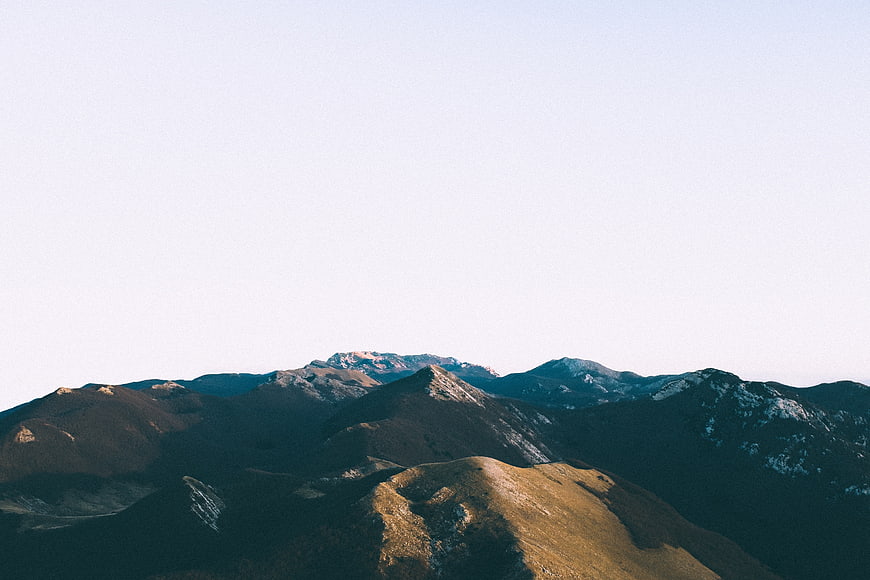 Serene Mountain Landscape with Snow-Capped Peaks and Clear Sky