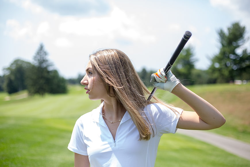Female Golfer Holding Club on Green Course