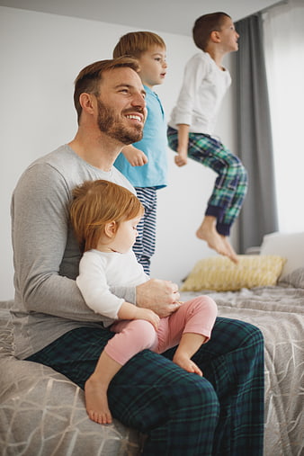 Happy Father with Three Children Playing in Bedroom