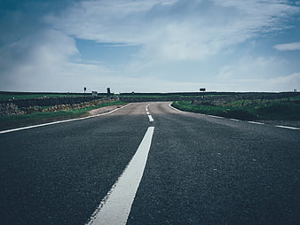 Empty rural road with stone walls and blue sky