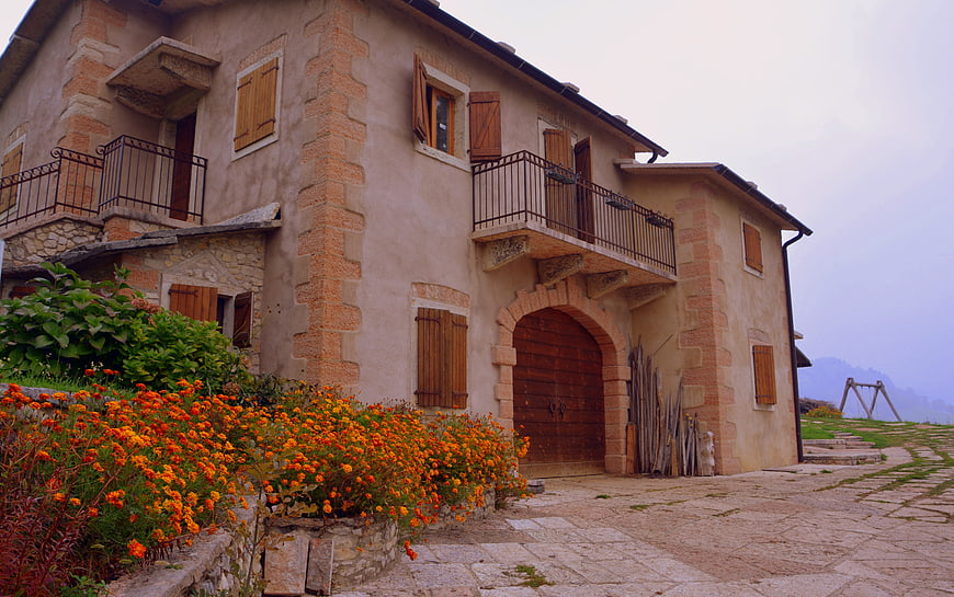 Rustic Stone House with Orange Flowers in Lessinia, Italy