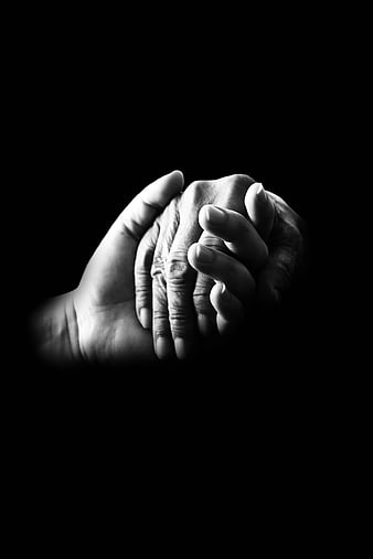 Black and white photo of elderly hands holding younger hands
