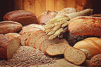Assortment of artisan bread loaves and wheat grains