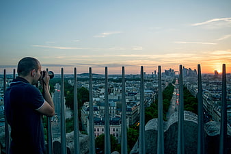 Photographer capturing Paris skyline at sunset from Eiffel Tower