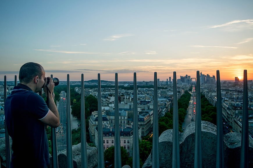 Photographer capturing Paris skyline at sunset from Eiffel Tower