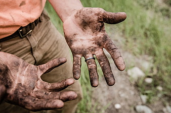 Close-up of dirty hands with soil and grease outdoors