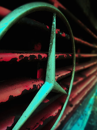 Close-up of weathered teal and red metal wheel rim