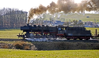 Vintage Steam Locomotive Emitting Smoke on Rural Railway Track