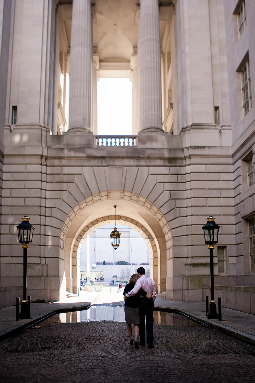 Couple walking through grand stone archway