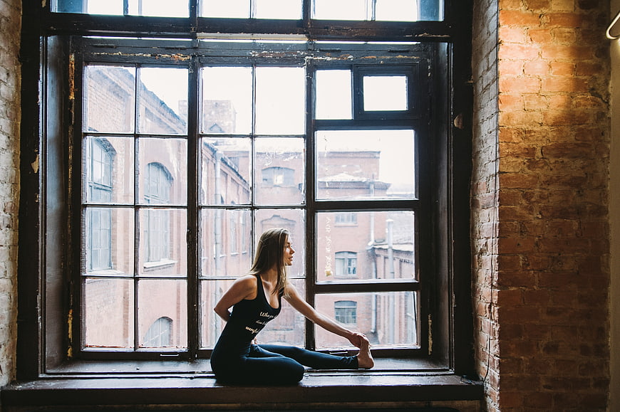 Woman stretching on large industrial window sill