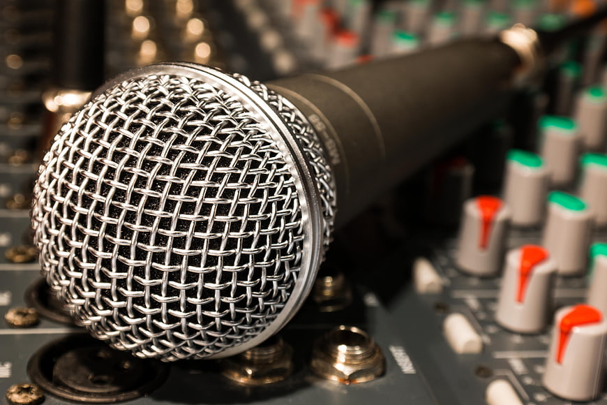 Close-up of dynamic microphone on audio mixing console