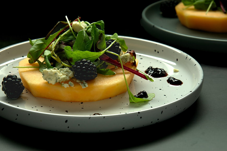 Gourmet melon salad with blackberries, blue cheese, and balsamic glaze