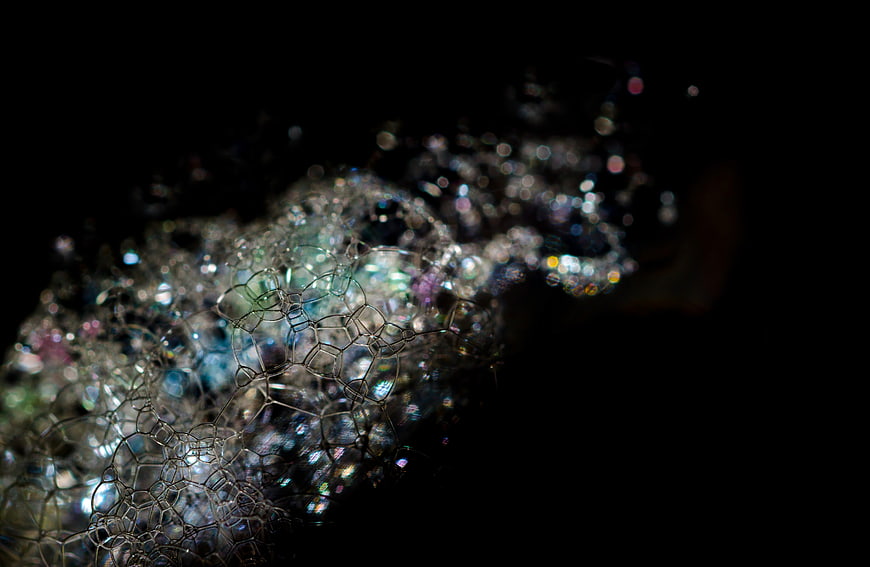 Abstract iridescent soap bubbles against black background