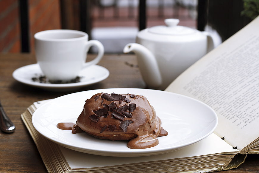 Chocolate Lava Cake with Tea and Open Book on Wooden Table