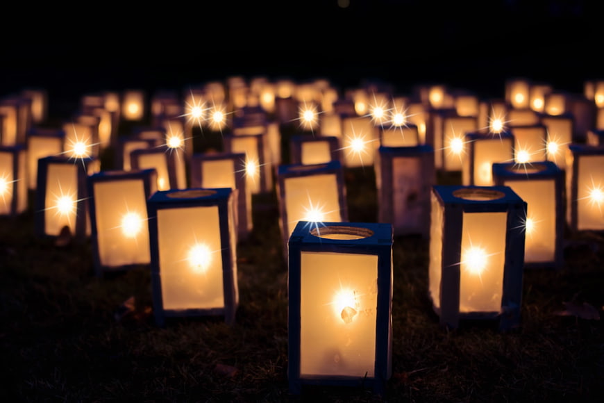 Rows of glowing lanterns on grass at night