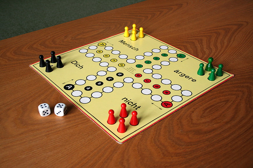 Mensch ärgere dich nicht board game with dice and pieces on wooden table