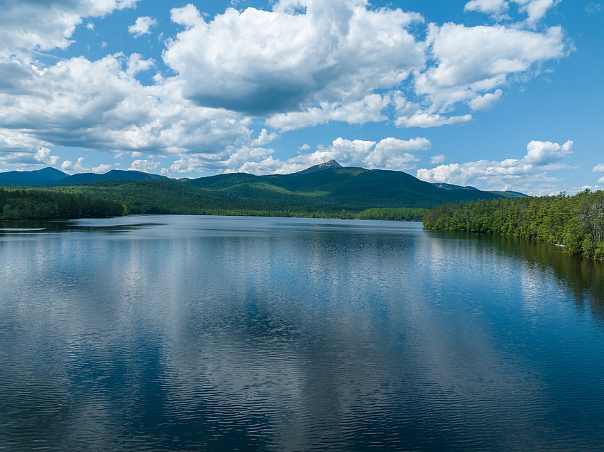 Serene Lake Landscape with Green Mountains and Blue Sky