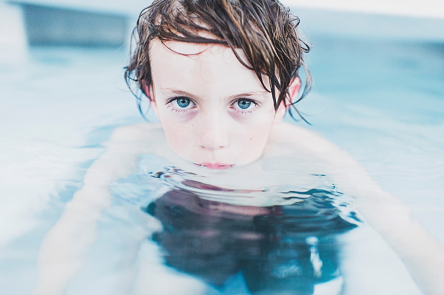 Close-up portrait of a young boy swimming in a pool