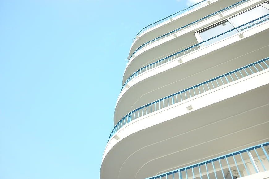 Low angle view of white curved building with blue railings