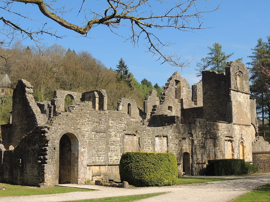 Historic stone abbey ruins with arched windows and blue sky