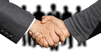 Business handshake with blurred team silhouettes in background