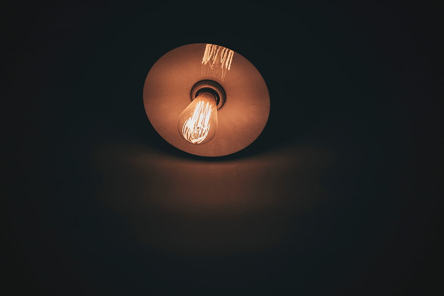 Vintage Edison Bulb in Ceiling Lamp Against Dark Background