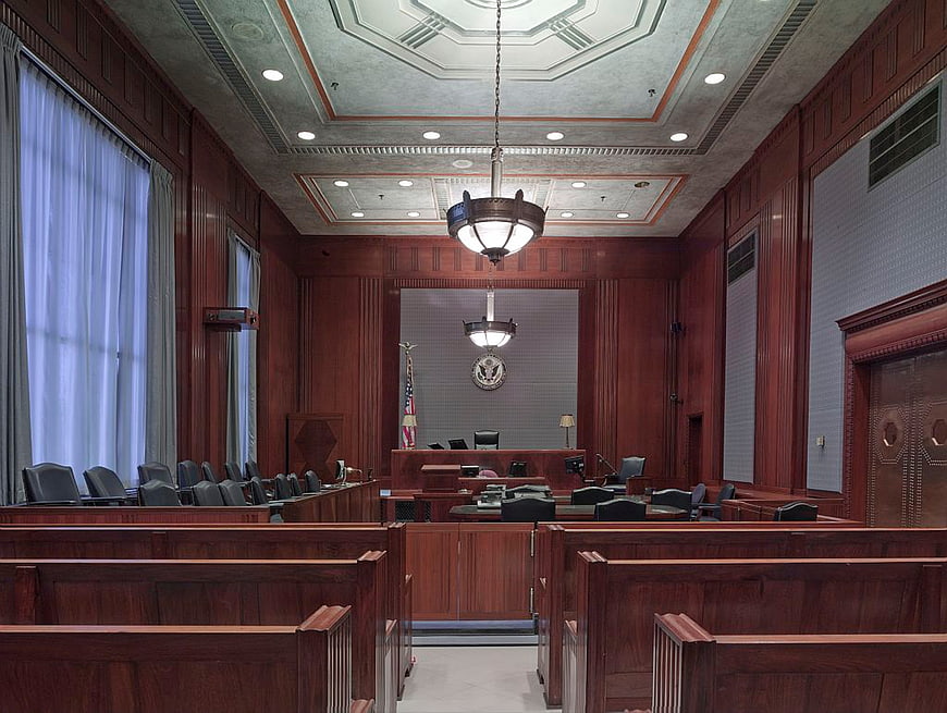 Empty wooden courtroom interior with judge bench and jury seating