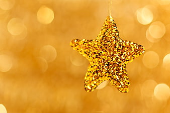 Golden Sequin Star Ornament on Bokeh Background